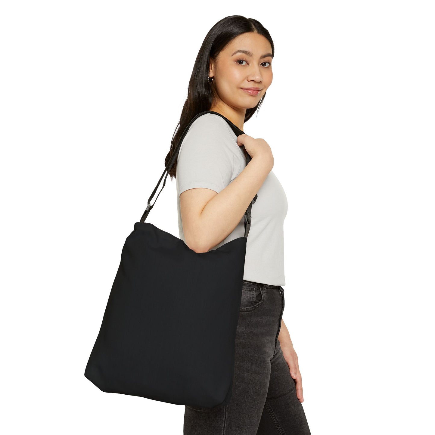 Woman holding a black tote bag against a white background
