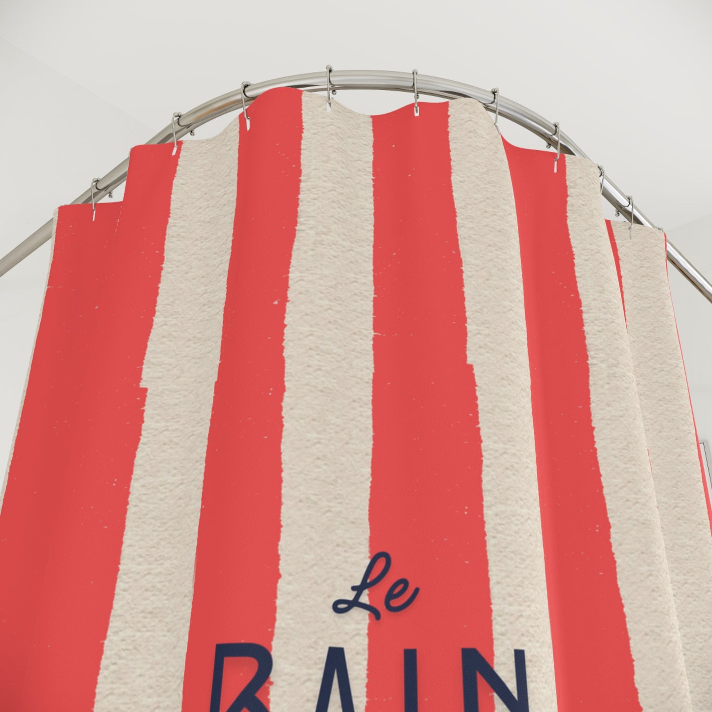 Red and beige striped fabric with 'Le Rain' text on a metal rod