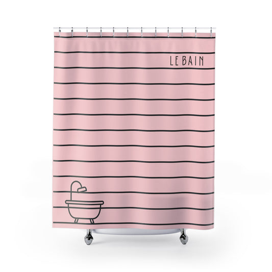 Pink shower curtain with thin black horizontal stripes, the word 'LE BAIN' printed near the top right, and a simple black line drawing of a bathtub at the bottom left. The curtain is shown hanging on a white rod against a clean white background.