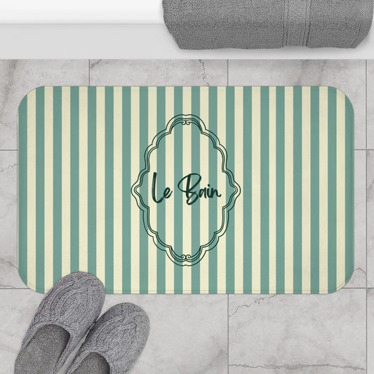 Striped bath mat with 'Le Bain' text on a bathroom floor.