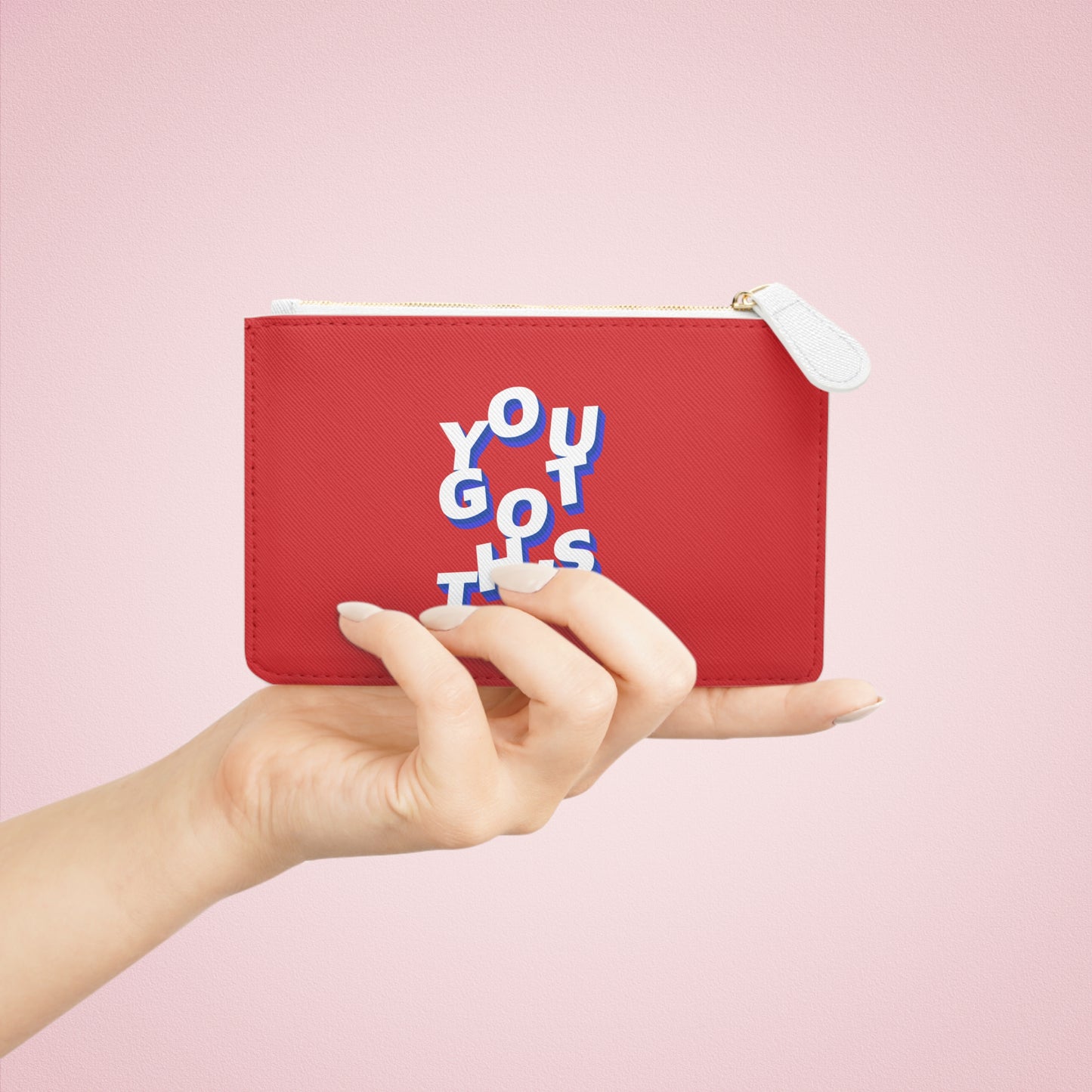 Red pouch with 'YOU GOT THIS' text held by a hand against a pink background
