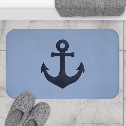 Blue bath mat with an anchor design on a tiled bathroom floor.