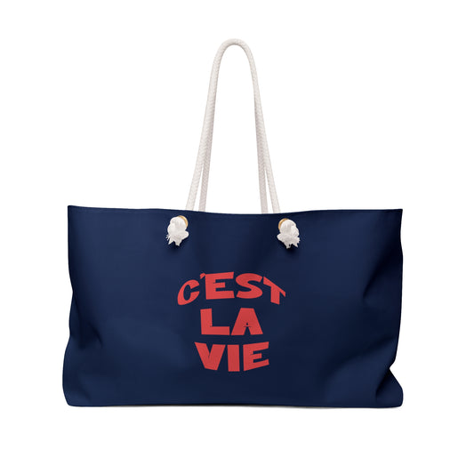 Navy blue tote bag with 'Cést La Vie' text on a white background