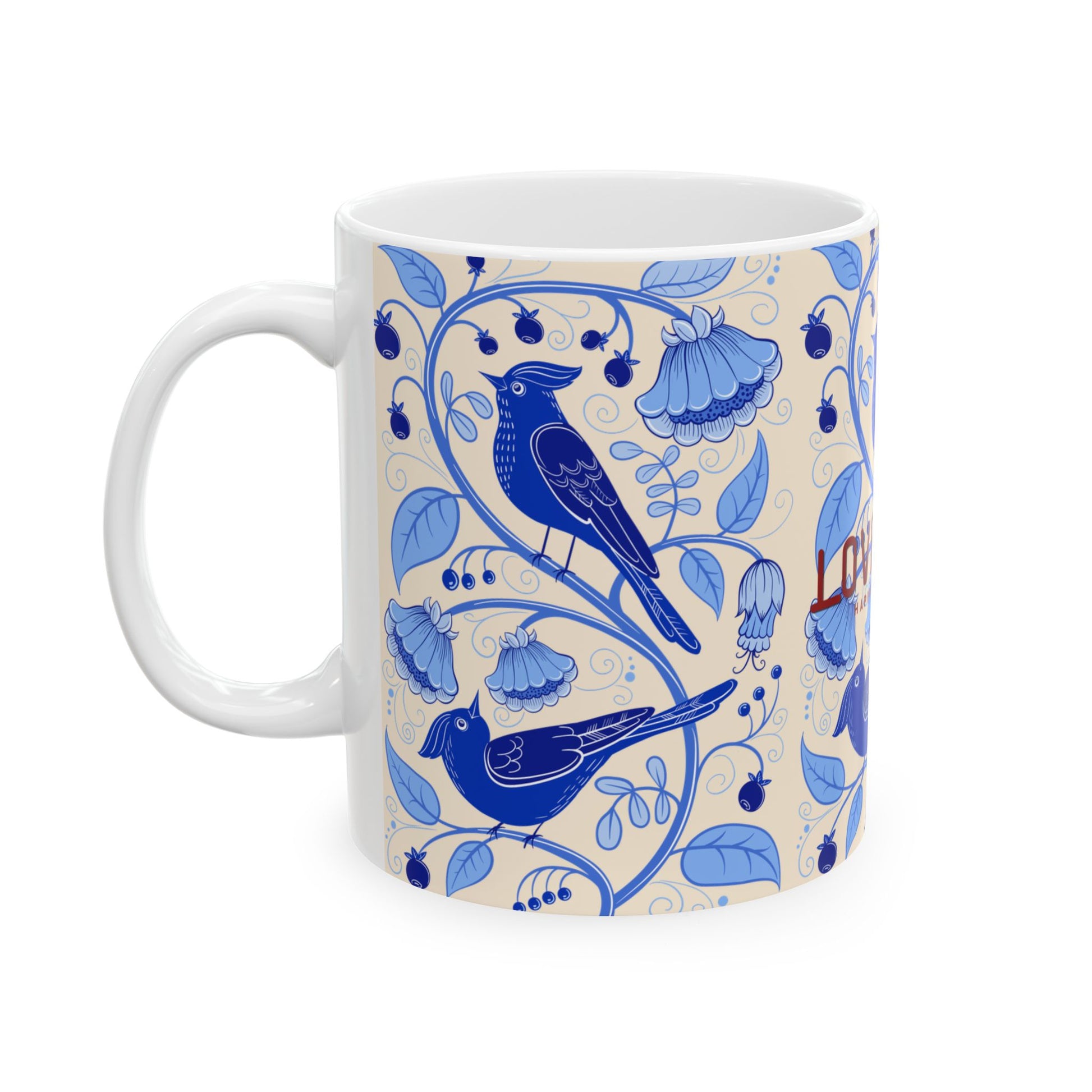 A white ceramic mug featuring a blue floral and bird pattern on a cream background, with the word 'LOVE' partially visible in red lettering.