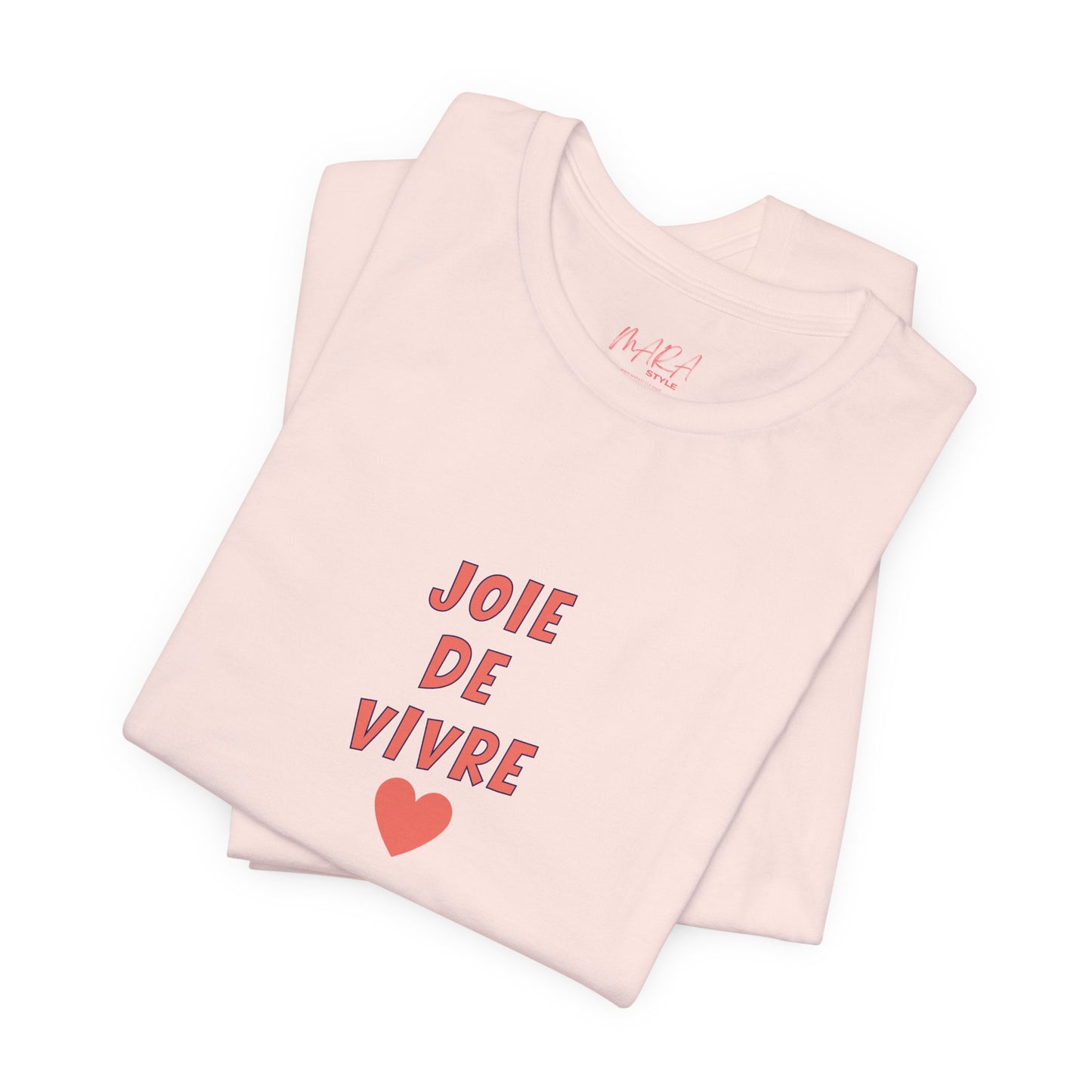 Folded pink tank top with 'Joie de Vivre' text and heart graphic on a white background