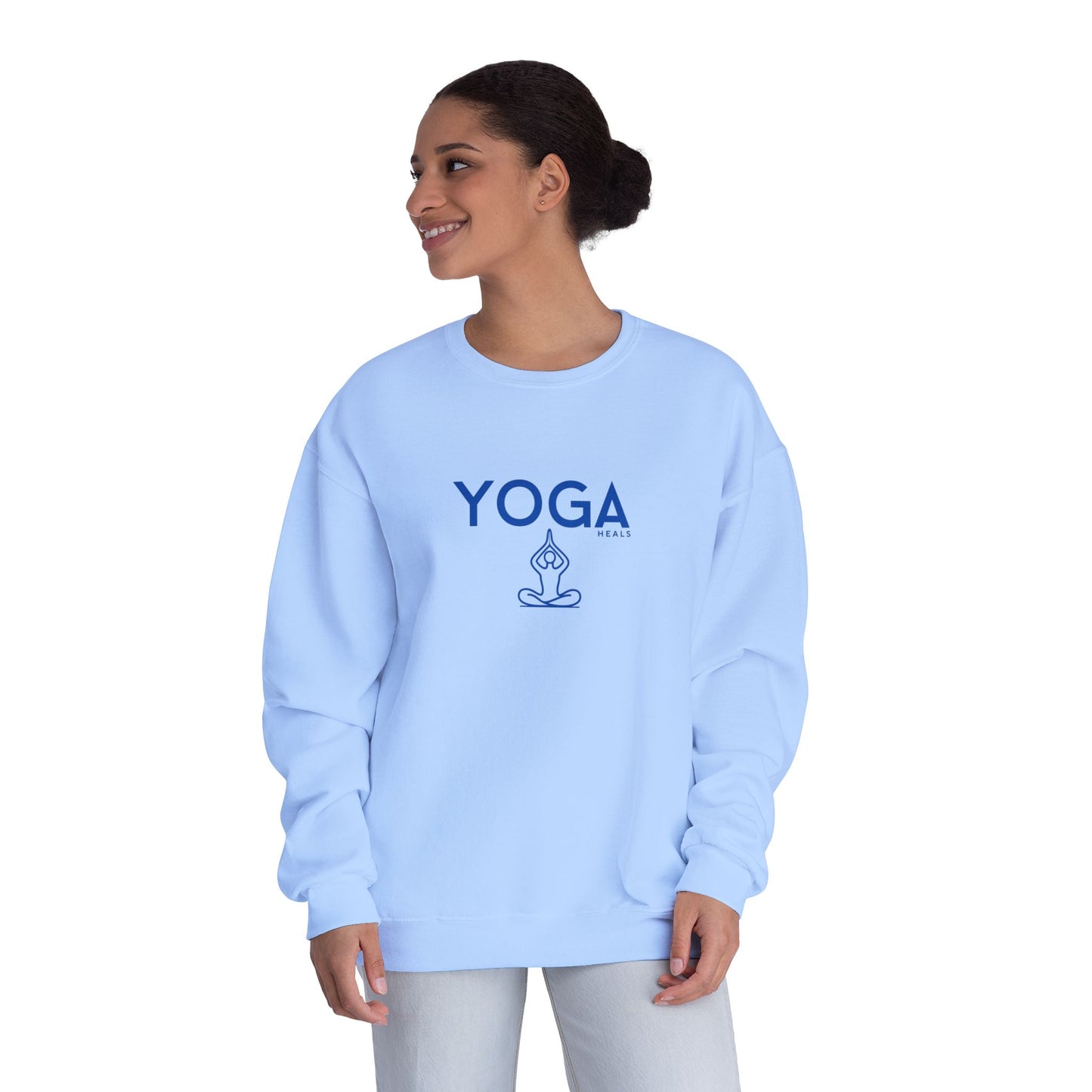 Woman wearing a light blue sweatshirt with 'YOGA HEALS' text on a white background
