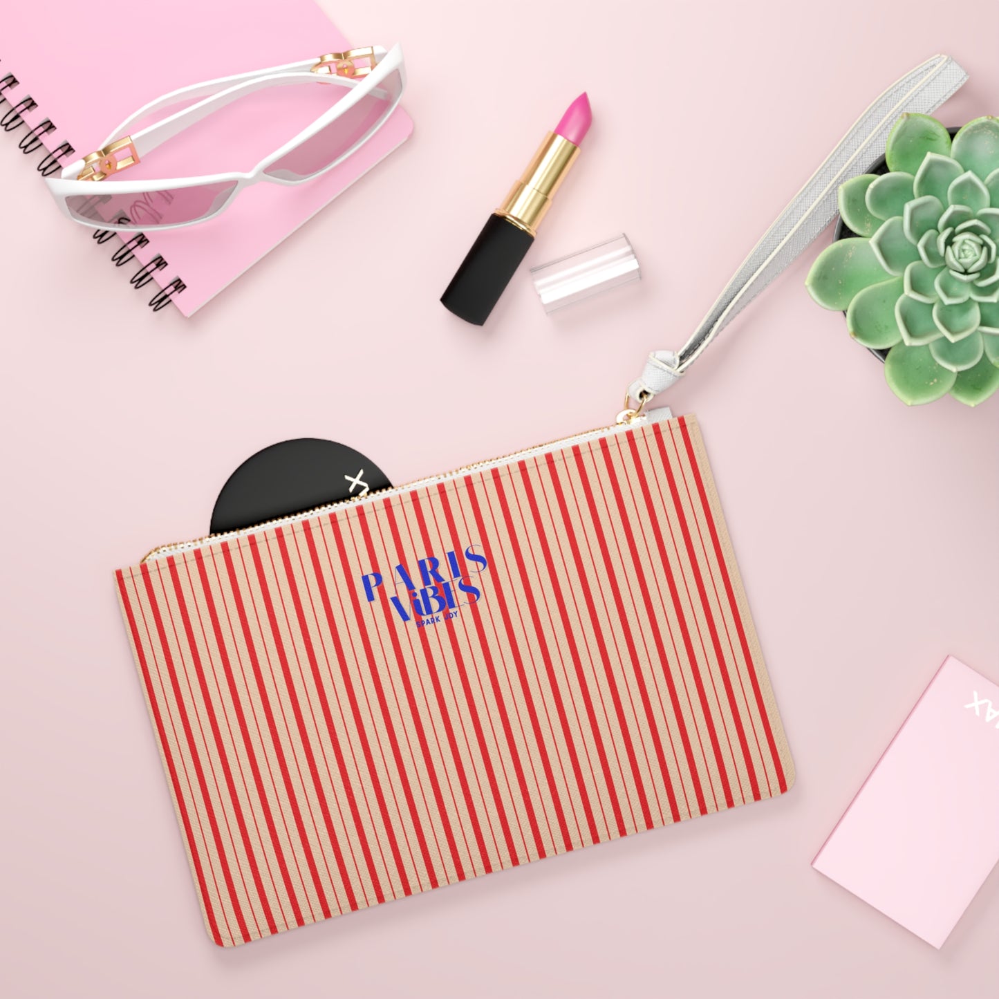 Striped pouch with 'Paris Love' text on a pink background with makeup items.