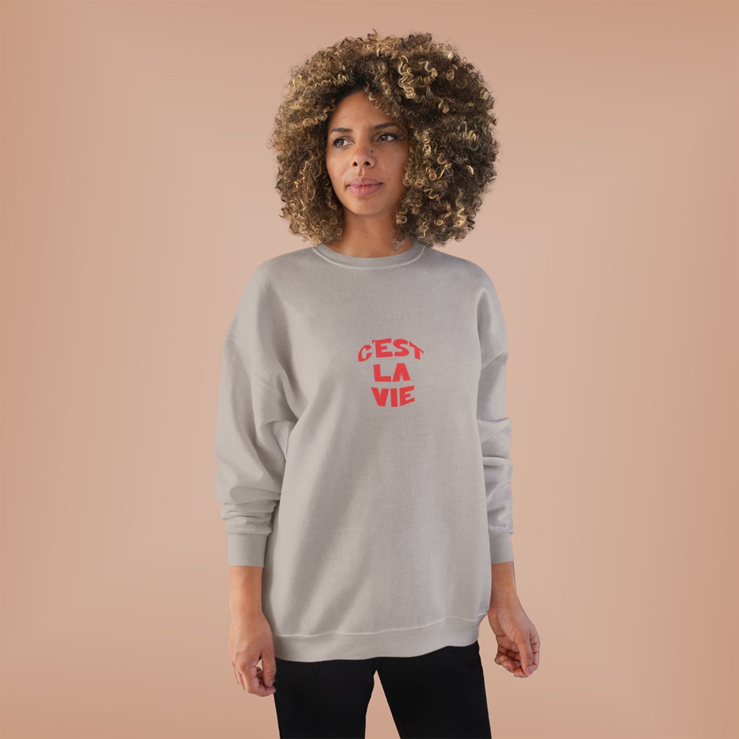Woman wearing a gray sweatshirt with red text on a beige background