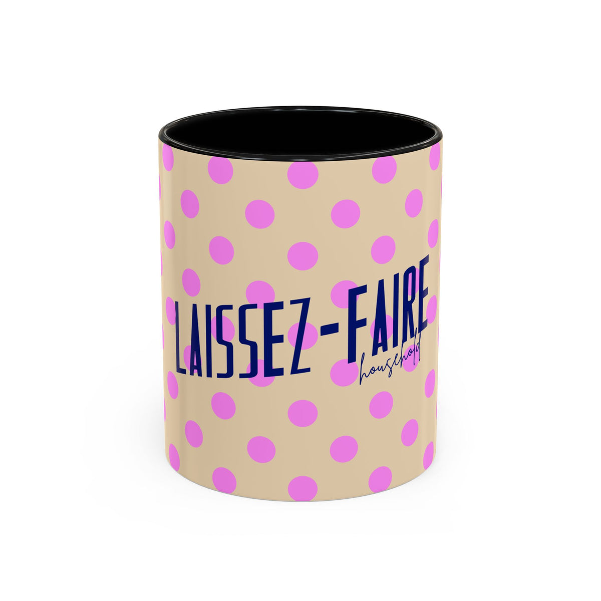A ceramic mug with a beige exterior patterned with pink polka dots and navy blue text reading 'LAISSEZ-FAIRE' and a smaller script brand name, shown on a clean white background.