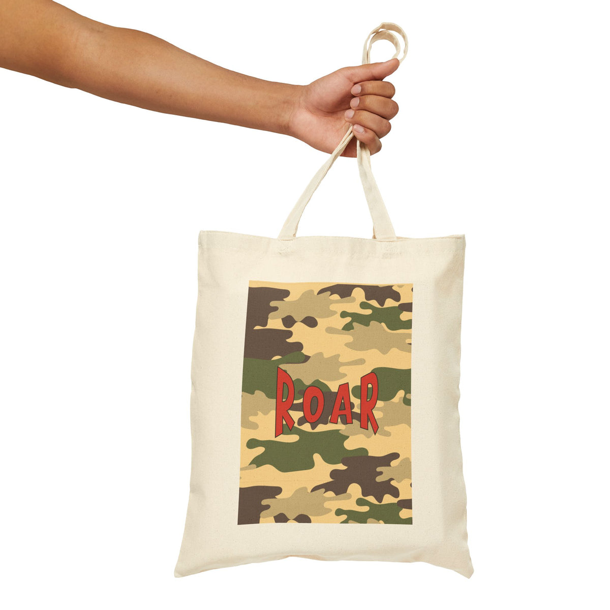 An off-white canvas tote bag with a camouflage print panel featuring the word 'ROAR' in red, held by a person's hand against a white background.