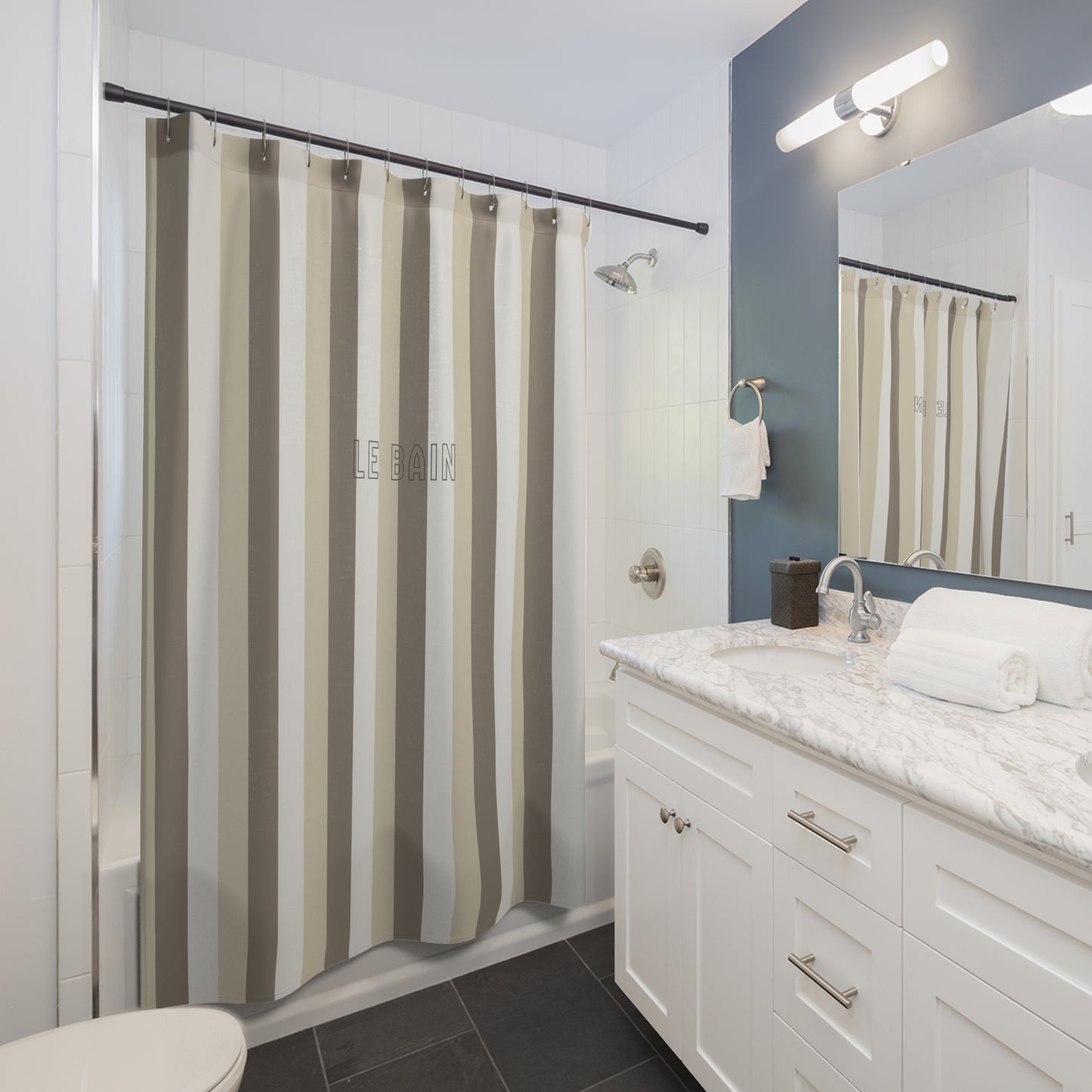 Bathroom with striped shower curtain, white vanity, and mirror.