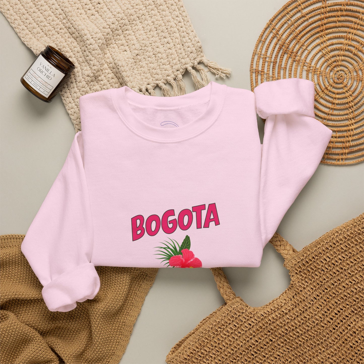 Pink sweatshirt with 'BOGOTA' text and floral design on a textured surface