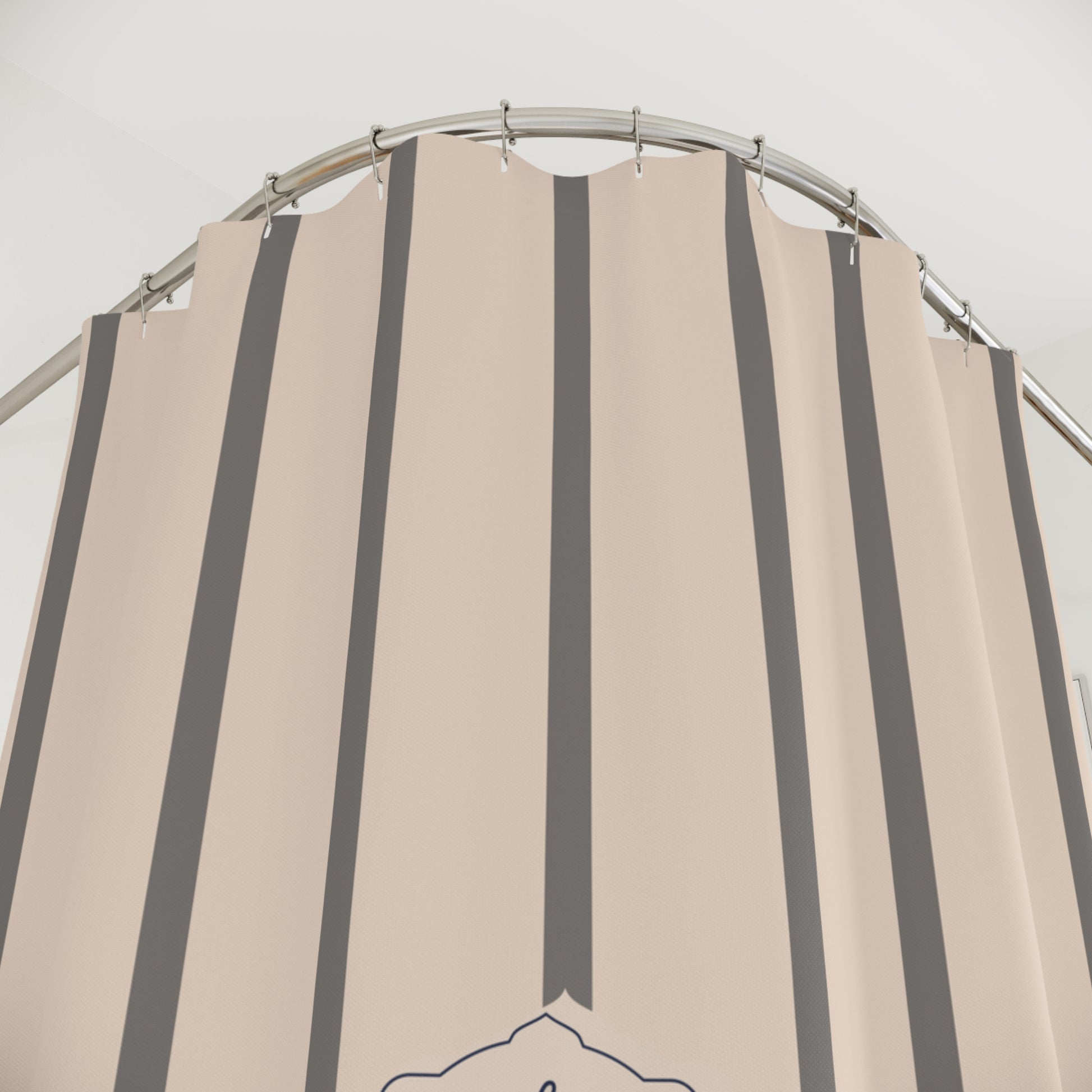 Beige and gray striped shower curtain on a metal rod against a white background
