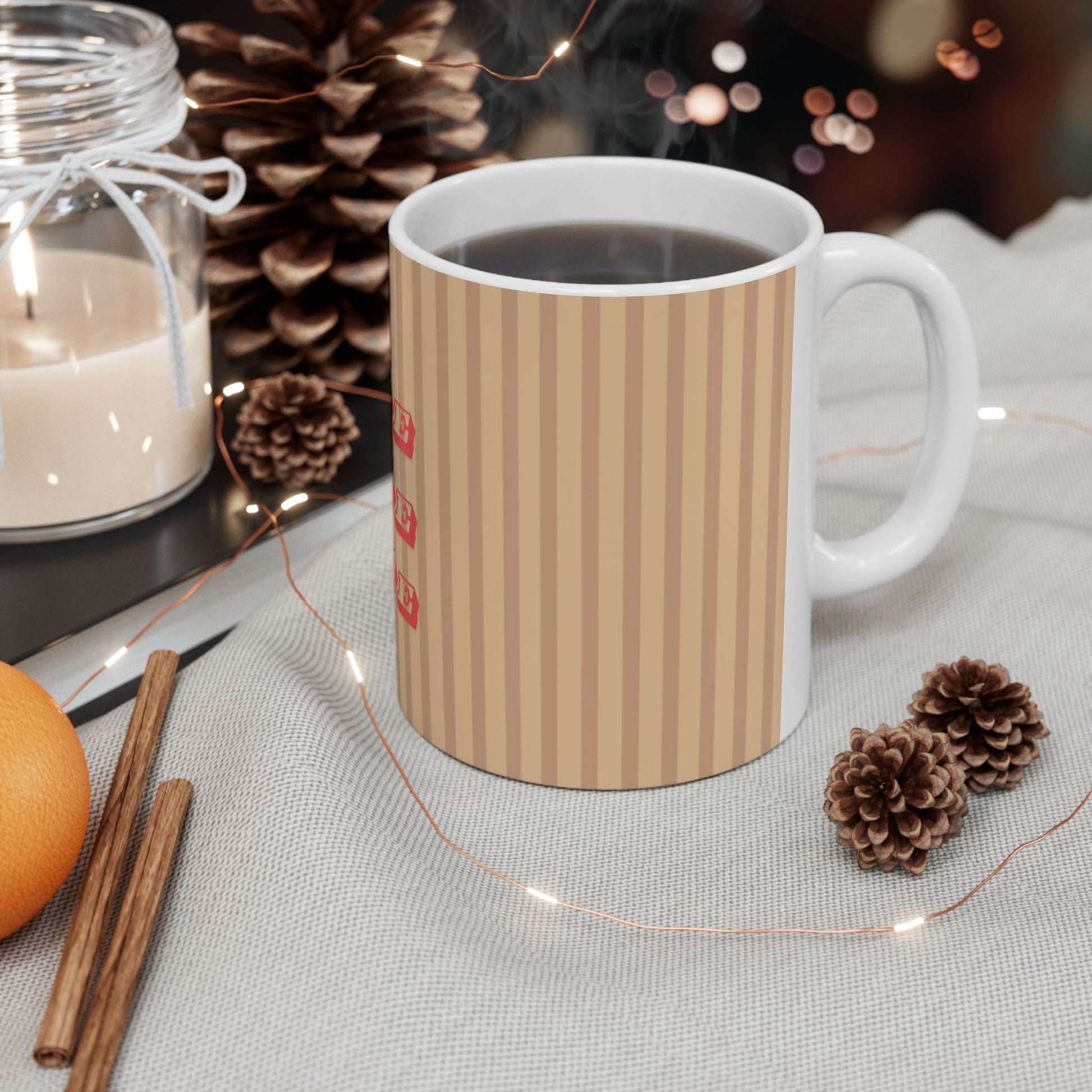 White mug with orange and pink striped design on a table with decorative items