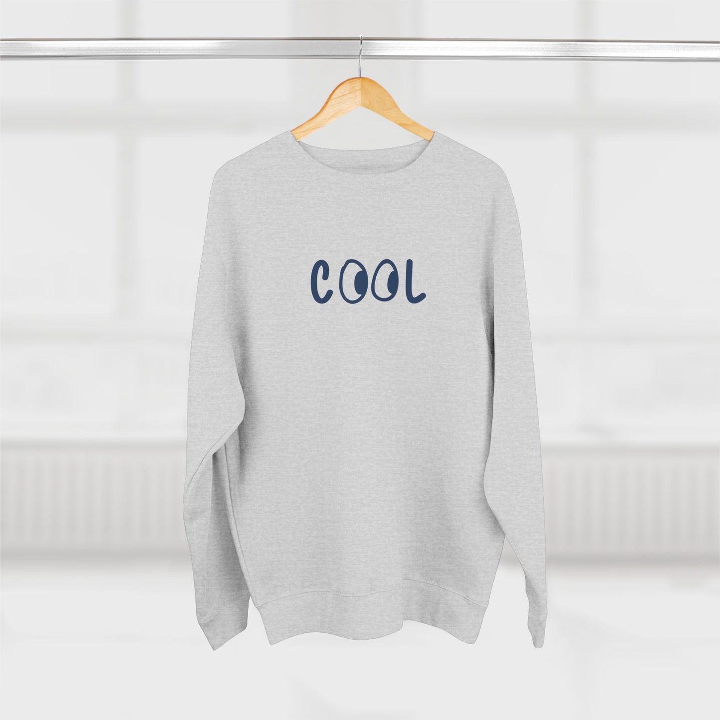 Gray sweatshirt with 'COOL' text on a hanger against a white background