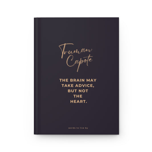 Black notebook with gold text featuring Truman Capote quote on a white background