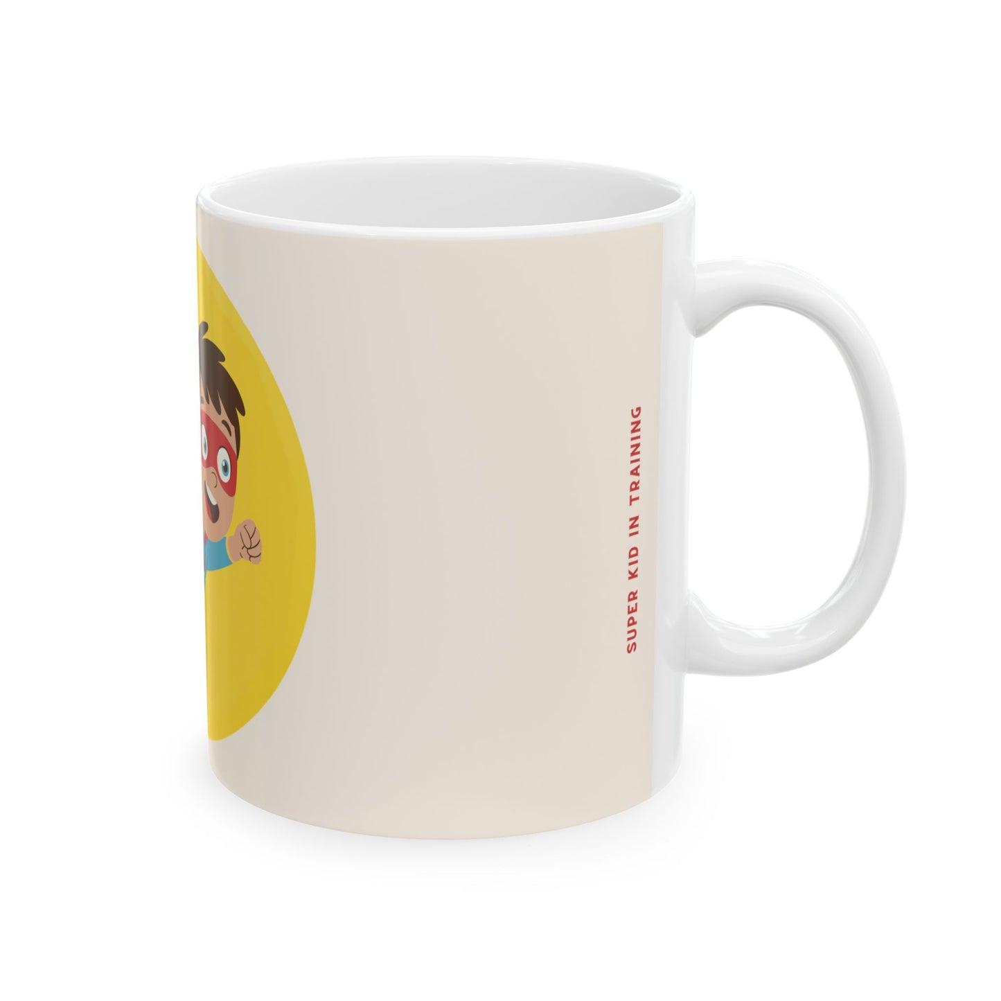 A white ceramic mug featuring a cartoon illustration of a child in a red superhero mask inside a yellow circle, with the text 'SUPER KID IN TRAINING' printed vertically in red on the side.
