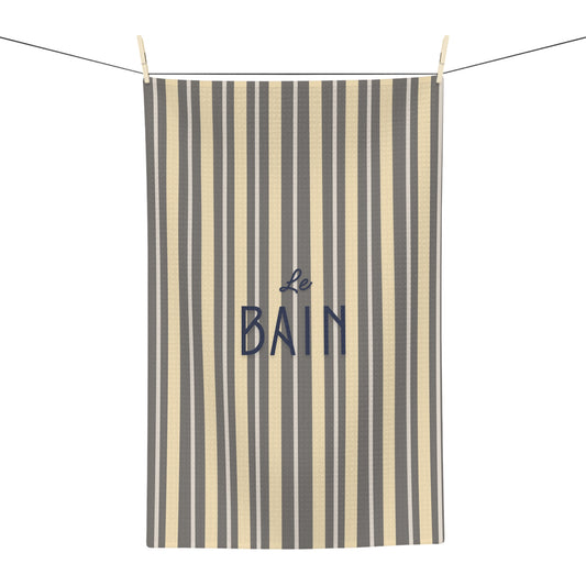 Striped towel with 'Le Bain' text hanging on a line