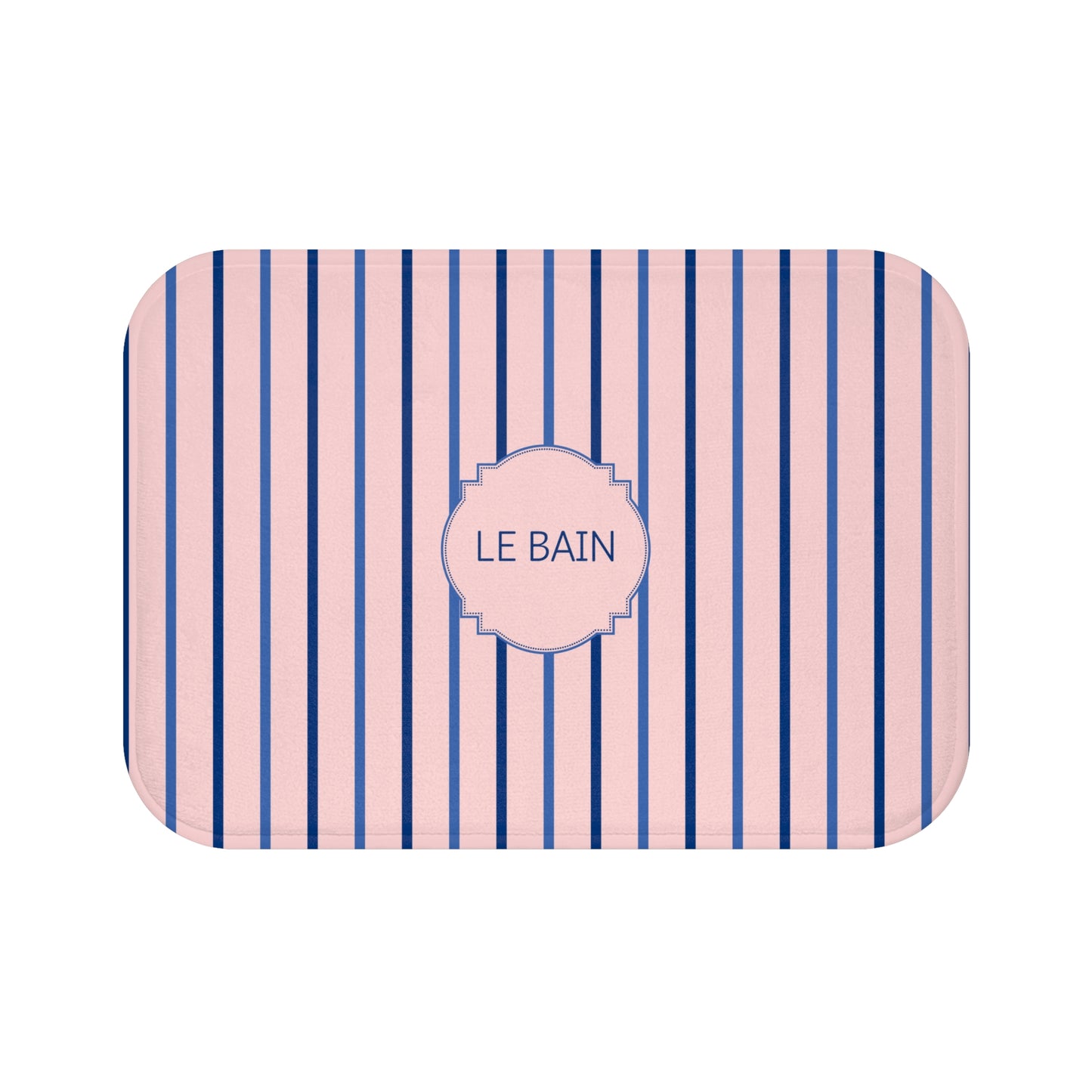 A rectangular bath mat with rounded corners, featuring vertical navy blue and light pink stripes with a central pink label that reads 'LE BAIN' in navy text.