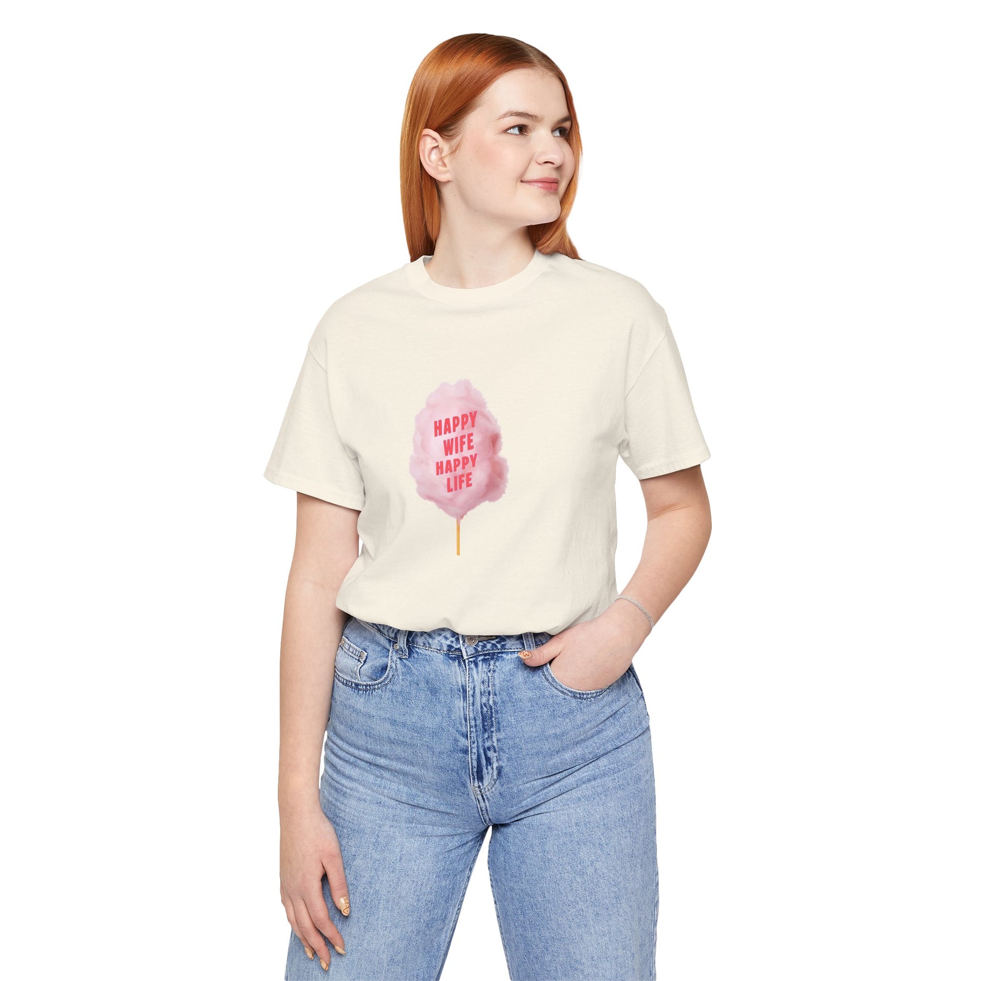 A woman with red hair wearing a white short-sleeve t-shirt with a pink cotton candy graphic on the front, paired with light blue jeans, against a plain white background.