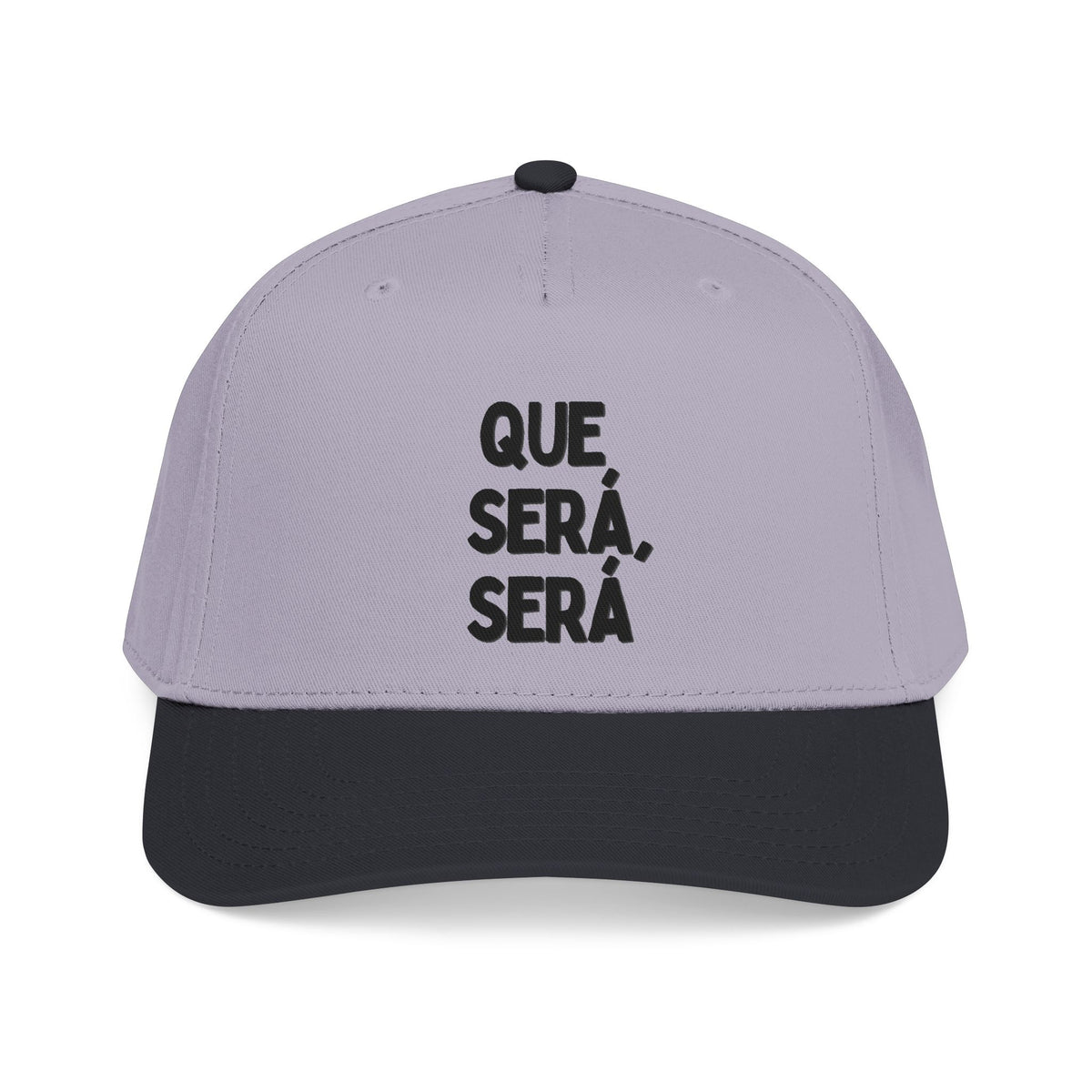 A two-tone baseball cap with a light lavender-purple crown and a black curved brim, featuring the Spanish text 'QUE SERÁ, SERÁ' printed in black on the front.
