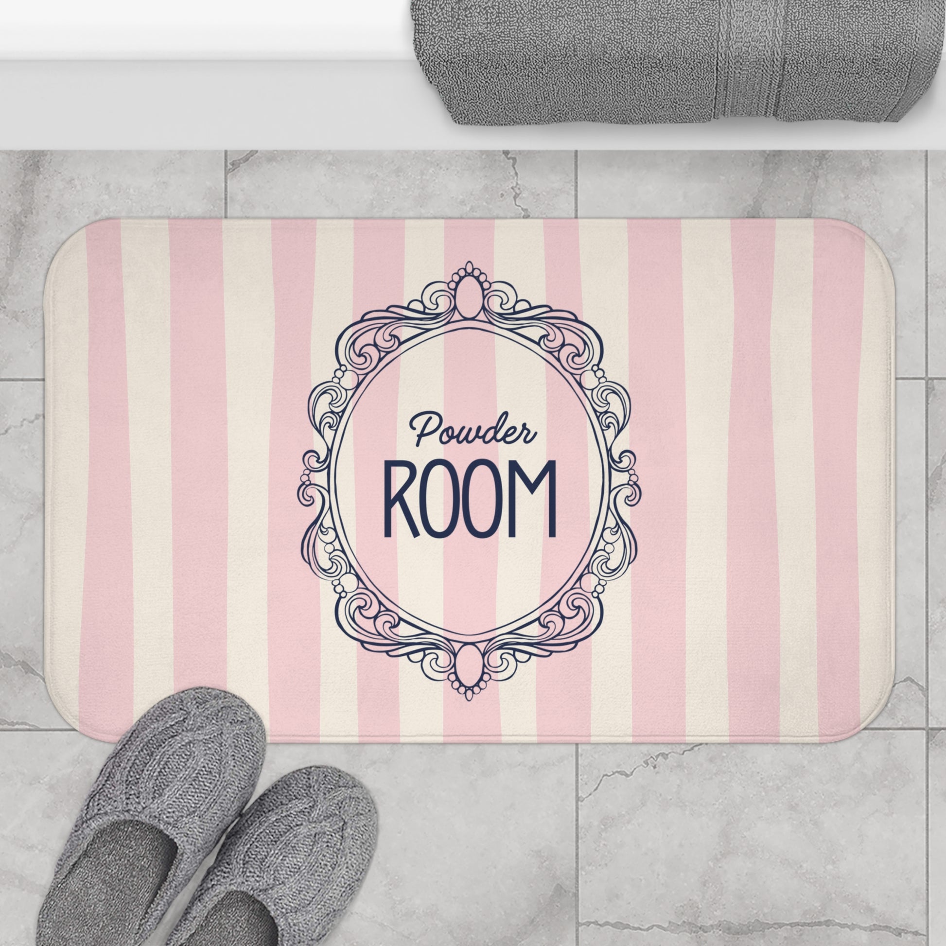 Bath mat with 'Powder Room' design on a striped background, placed on a marble floor.
