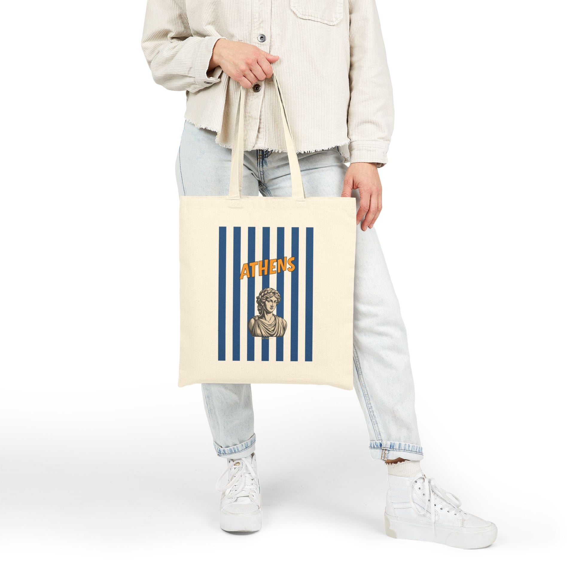 Person holding a tote bag with 'Athens' design on a white background