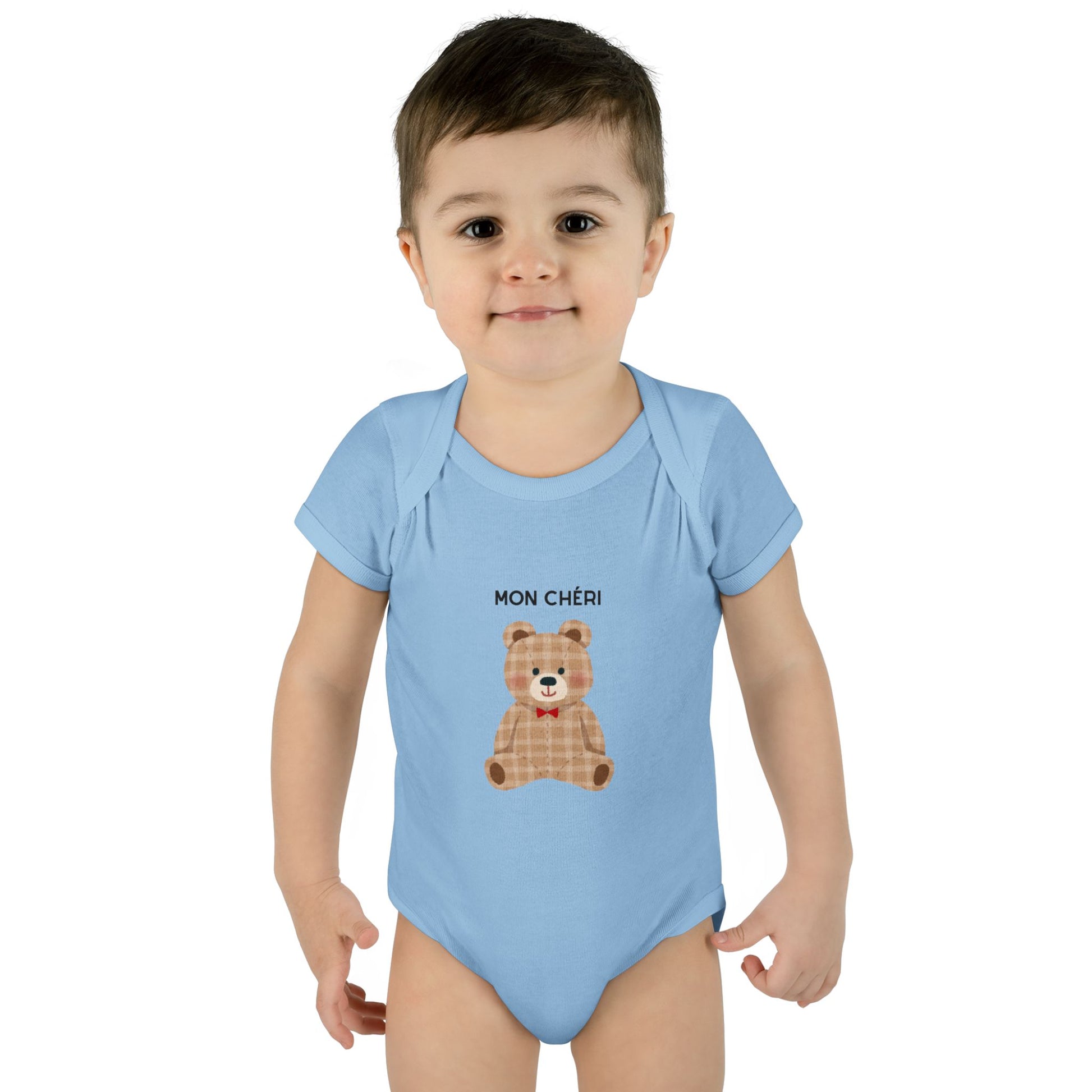 Child wearing a light blue onesie with a teddy bear design and text on a white background