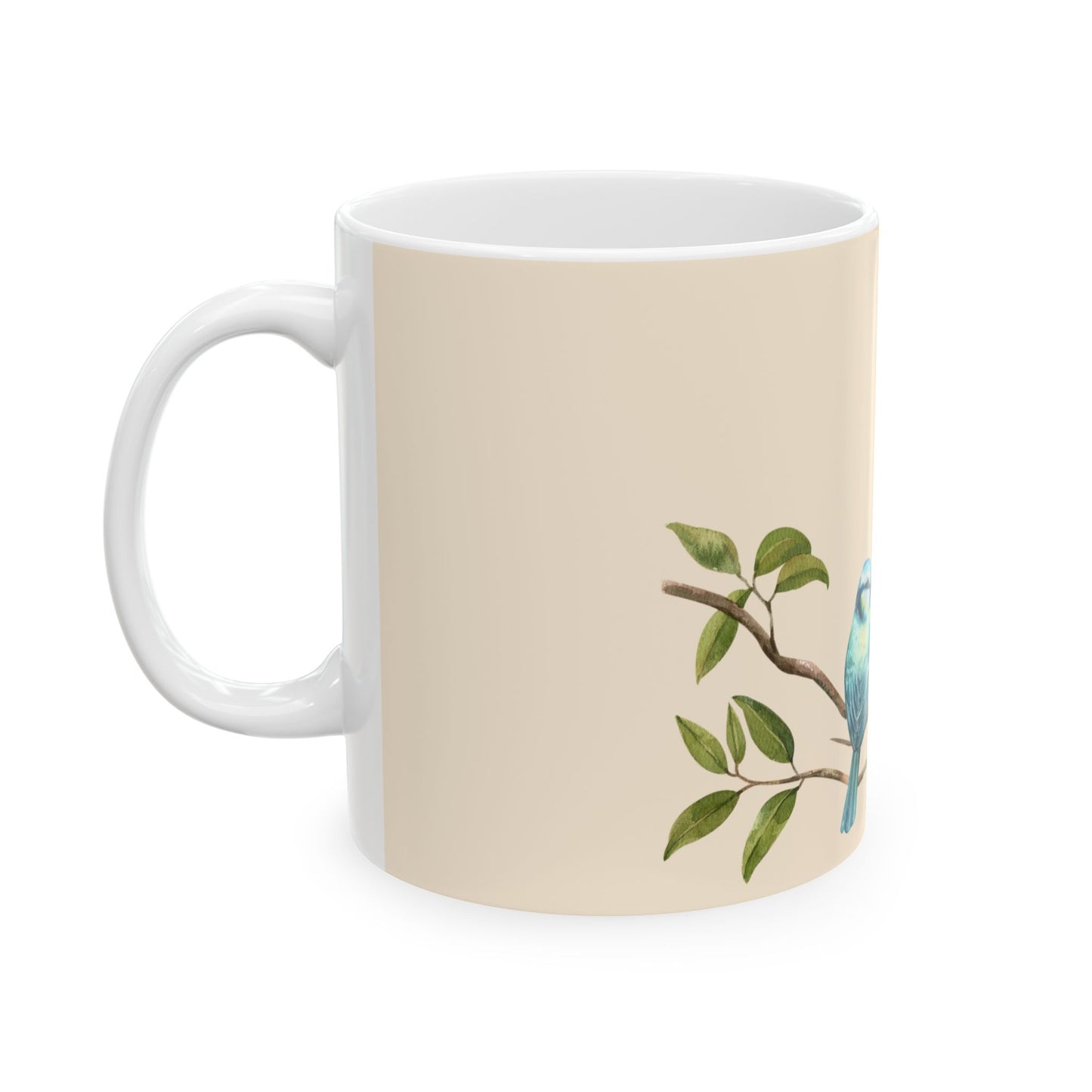 A white ceramic mug with a beige printed wrap-around design featuring a green leafy branch and a light blue bird on the right side, shown against a plain white background.