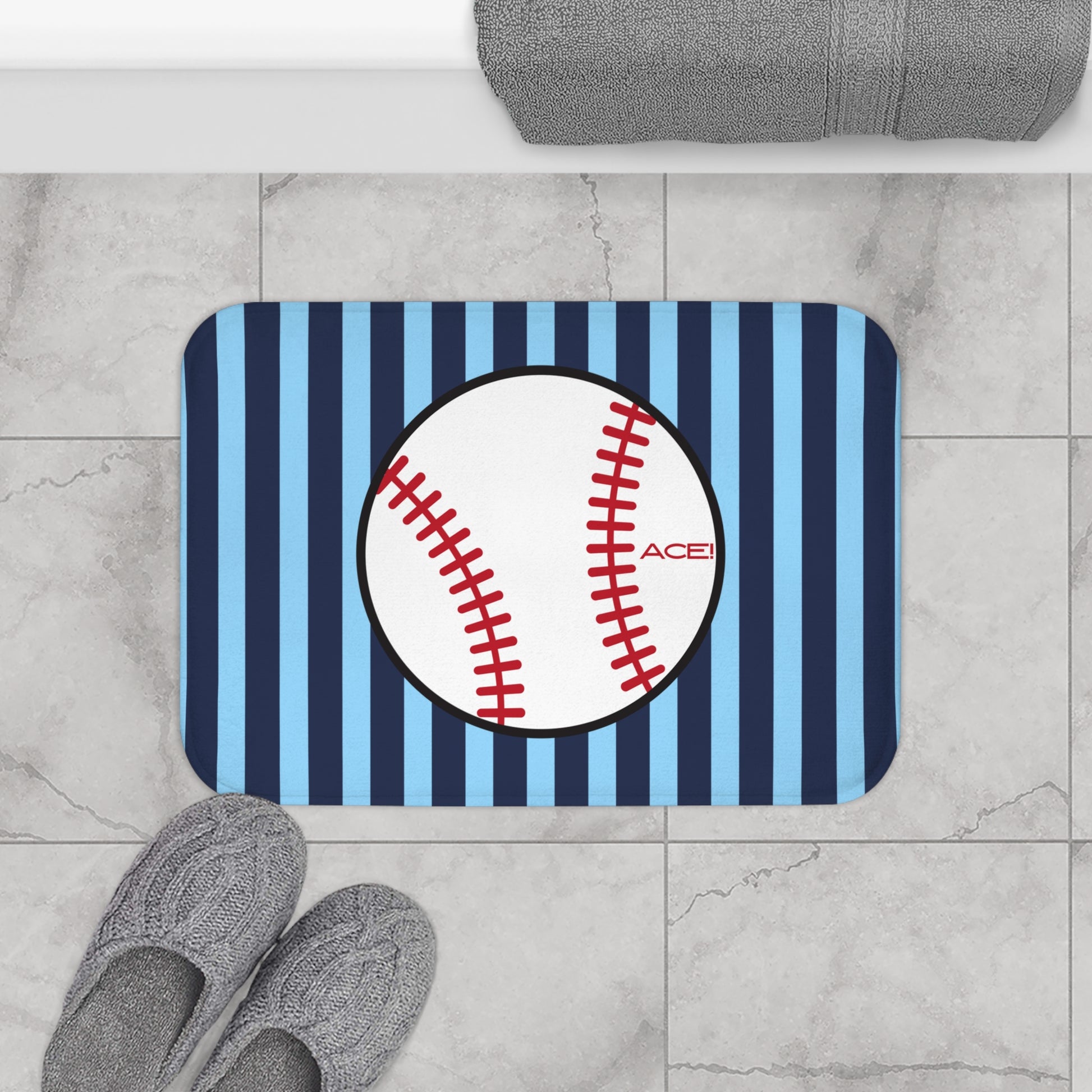 Doormat with baseball design on a striped background, placed on a tiled floor.