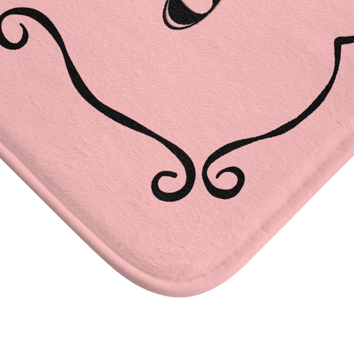 A close-up of a pink bath mat with rounded corners and a black decorative swirl pattern, shown against a white background.