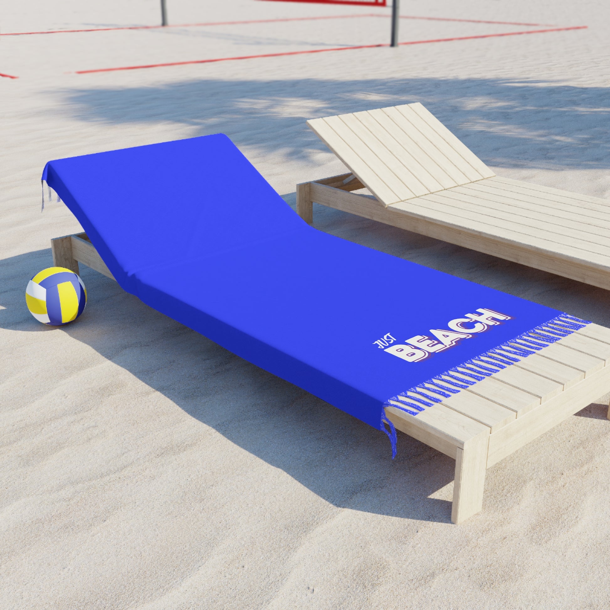 Blue beach towel with 'Beach' text on a wooden lounge chair by a poolside.