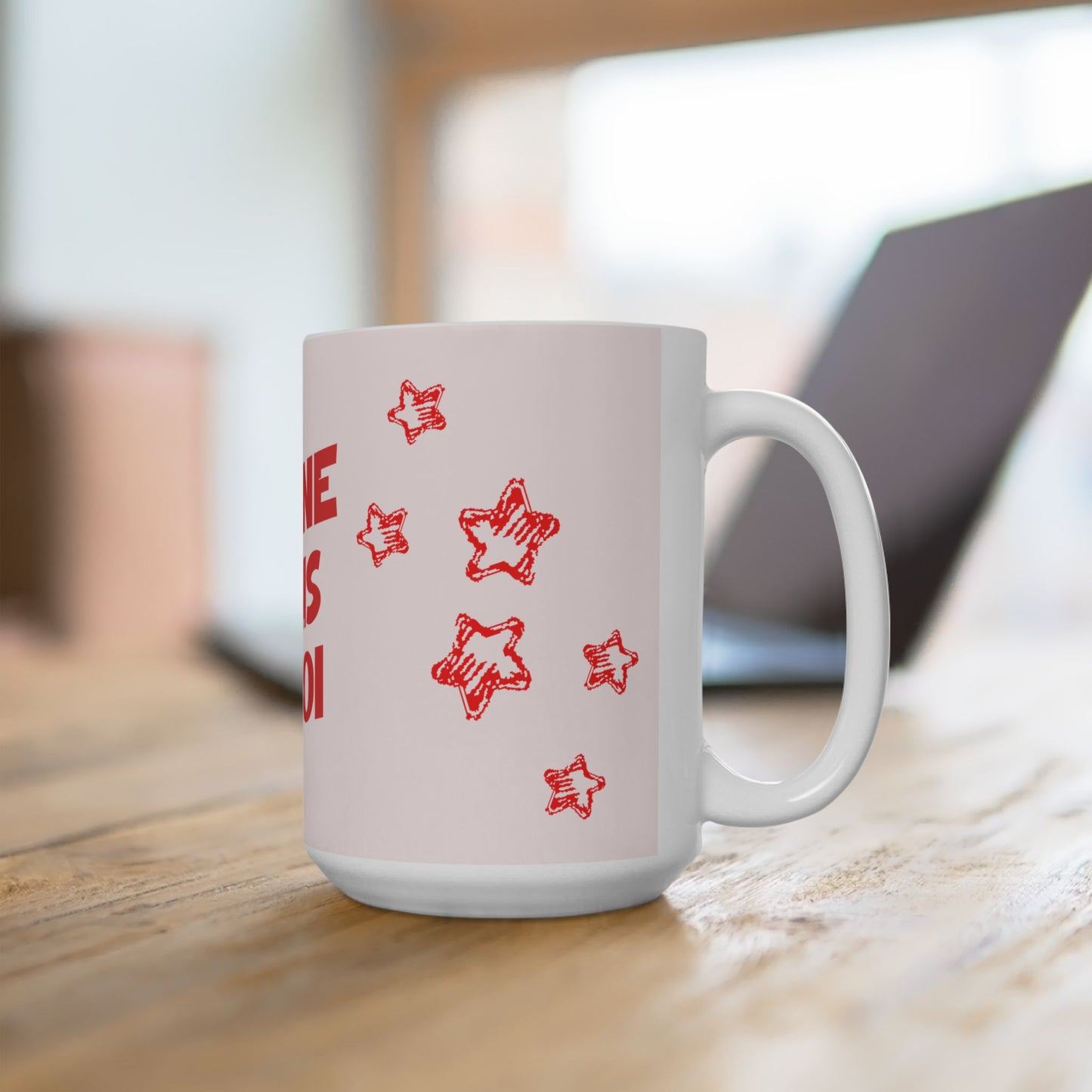 White mug with red star patterns on a wooden surface