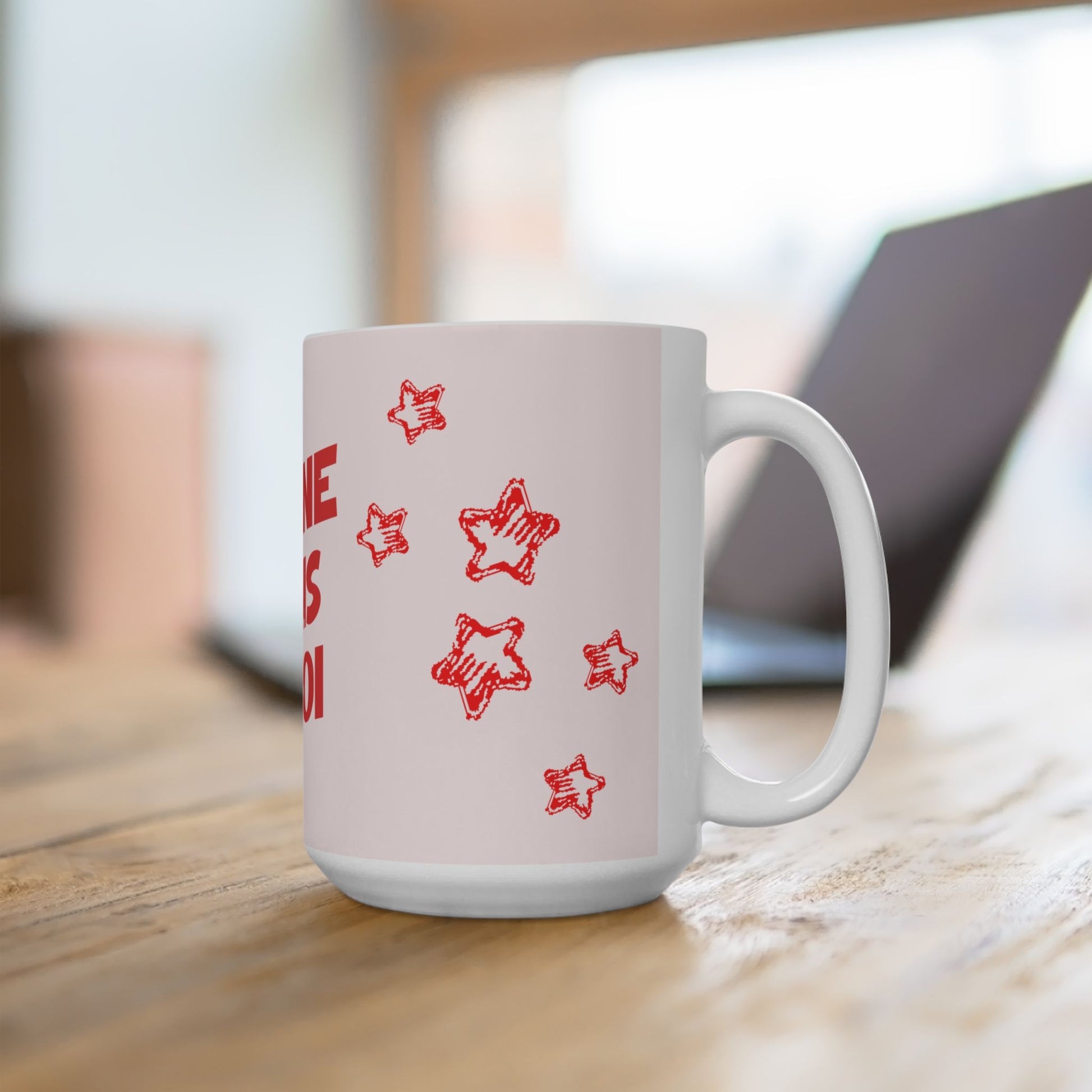 White mug with red star patterns on a wooden surface