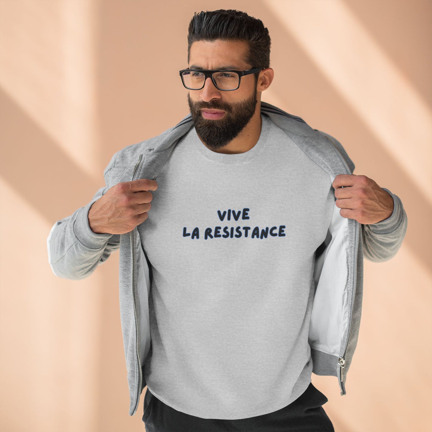 Man wearing a gray sweatshirt with 'Vive La Resistance' text against a beige background