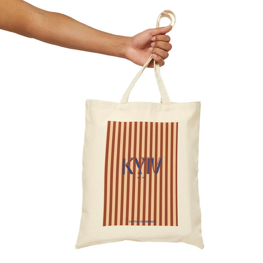 Tote bag with 'KYIV' text and striped pattern held by a hand on a white background