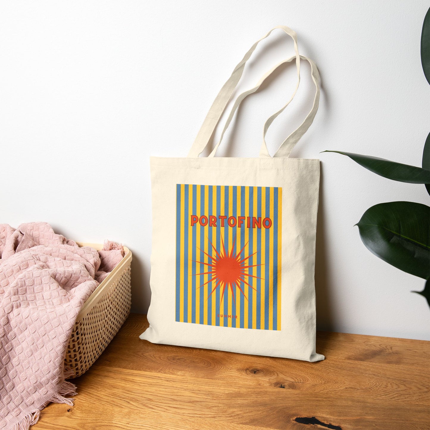 Tote bag with 'Portofino' design on a wooden surface with a white wall background