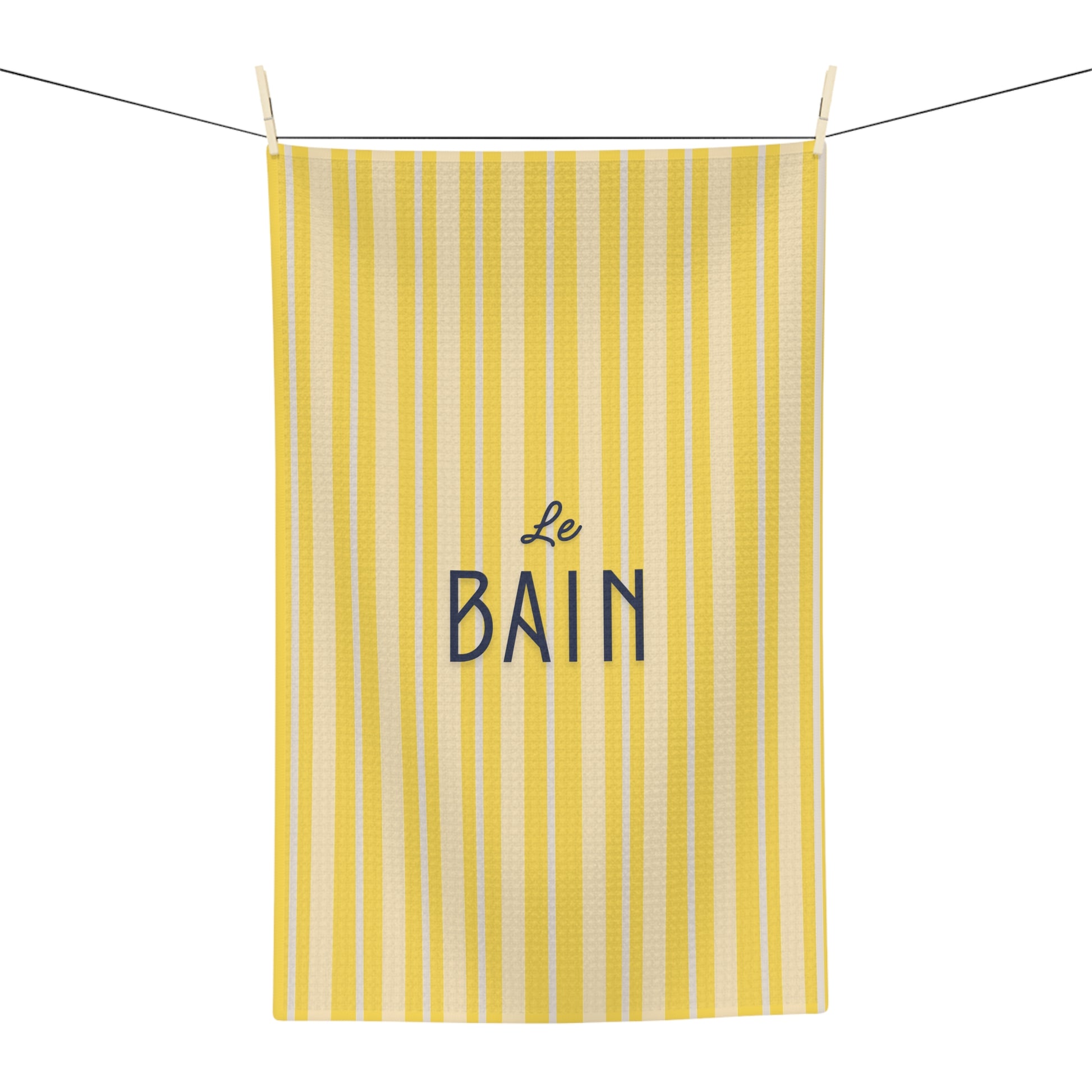 Yellow striped towel with 'Le Bain' text on a white background