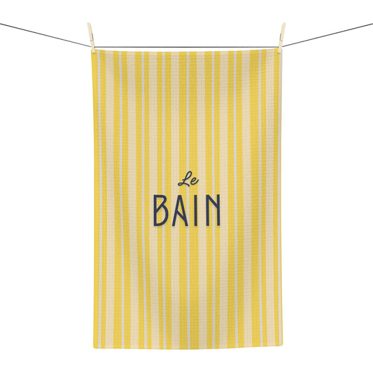 Yellow striped towel with 'Le Bain' text on a white background