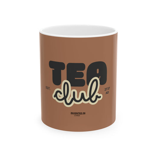 A brown ceramic mug with a white interior, featuring a graphic design that reads 'TEA club' in black and cream lettering, with 'EST. 2757 AD' and 'INVENTED IN CHINA' printed below.