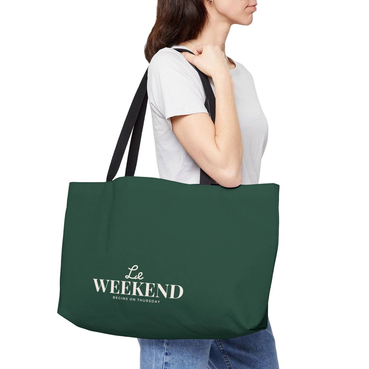 Person holding a green tote bag with 'Le Weekend Begins on Thursday' text.