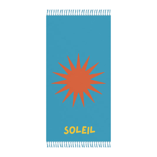 Blue towel with orange sun design and 'Soleil' text on a white background
