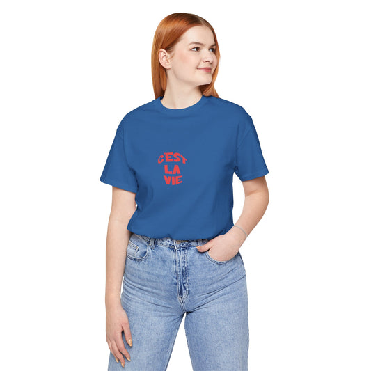 Person wearing a blue t-shirt with red text 'Cés La Vie' on a white background