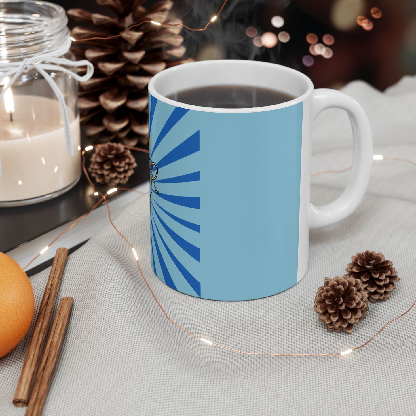 White mug with blue design on a table with decorative items