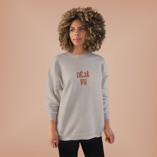 Person wearing a gray sweatshirt with 'DEJA VU' text on a beige background