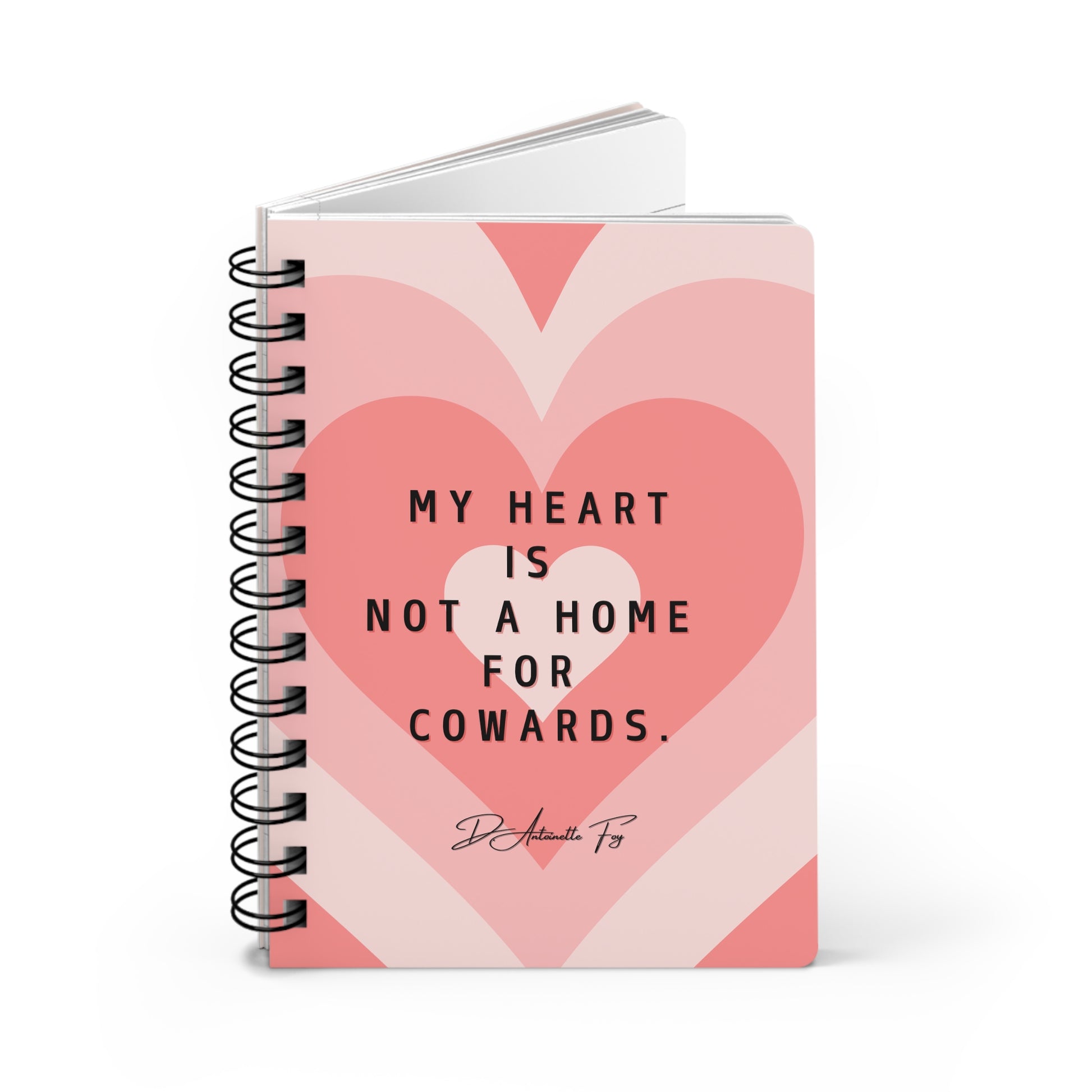 Notebook with pink heart design and motivational quote on a white background
