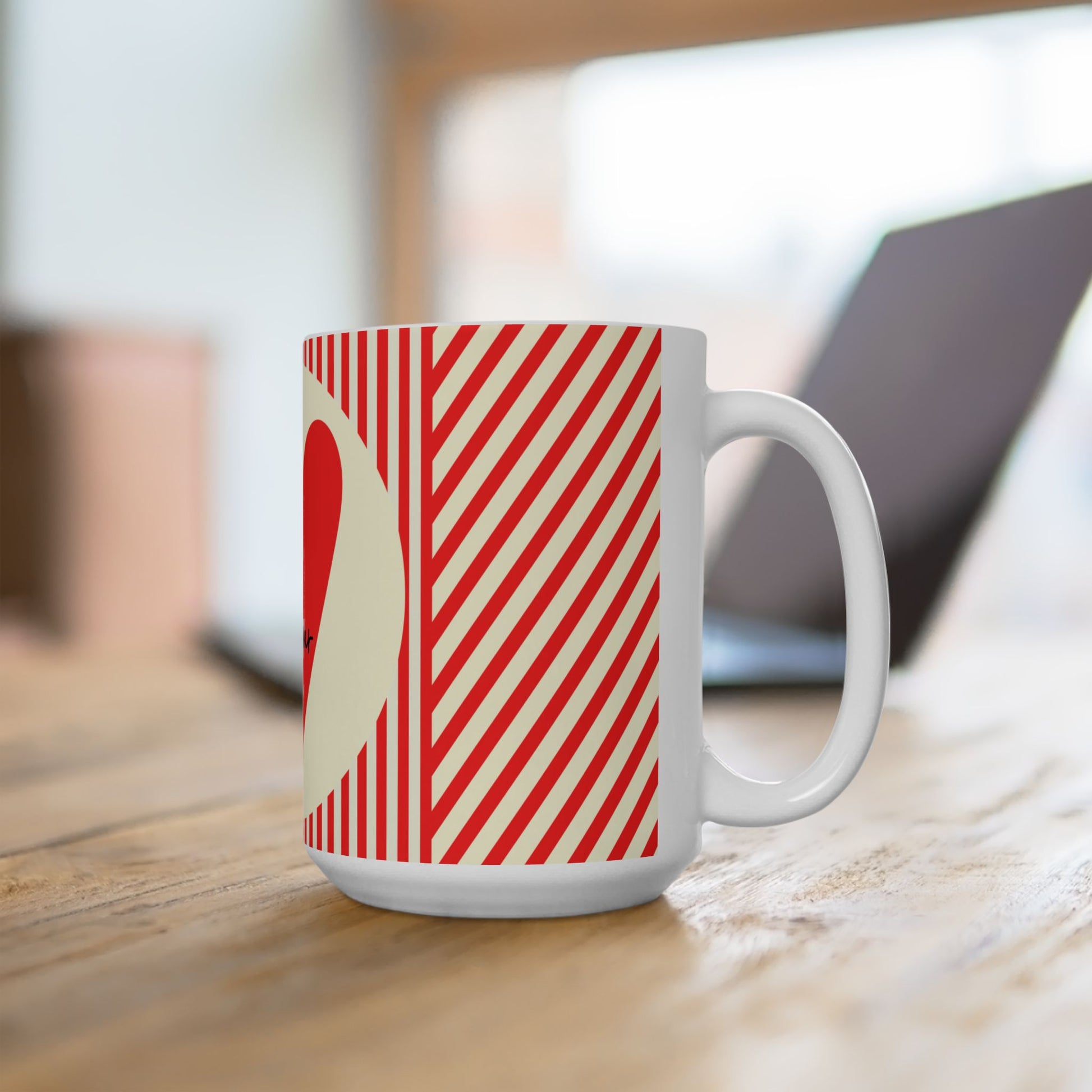 White mug with red and beige striped pattern on a wooden surface