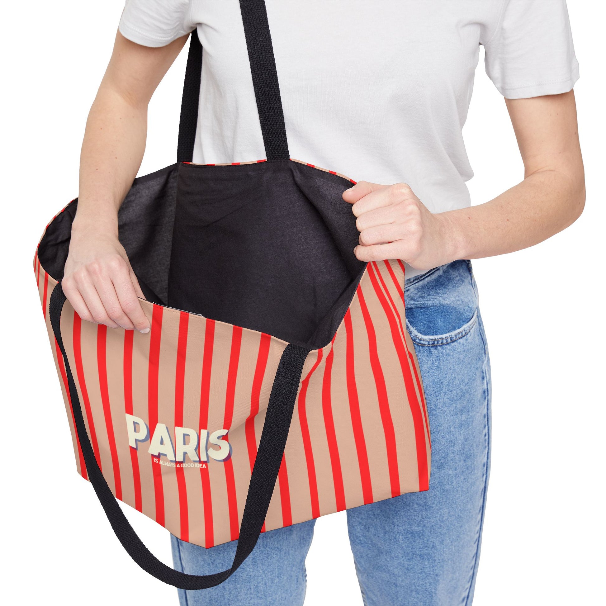 Person holding a striped bag with 'PARIS' text on a white background