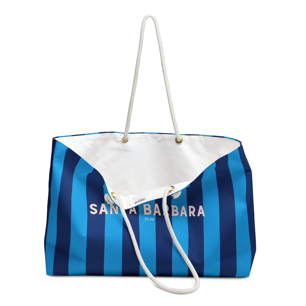 A striped beach tote bag with blue and navy vertical stripes, a white interior lining, and white rope handles. The front features the text 'SANTA BARBARA' in white.