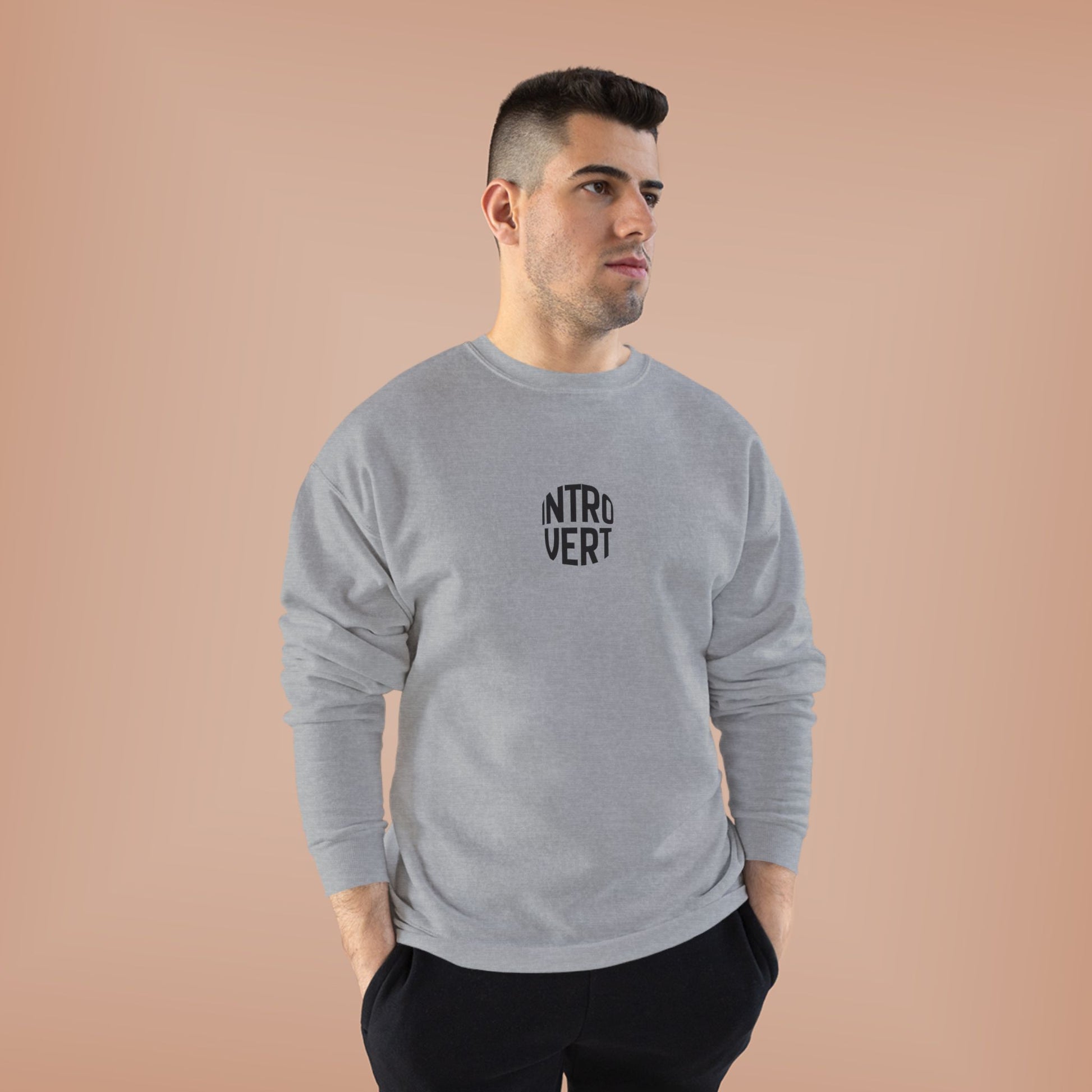 Man wearing a gray sweatshirt with 'INTROVERT' text on a beige background